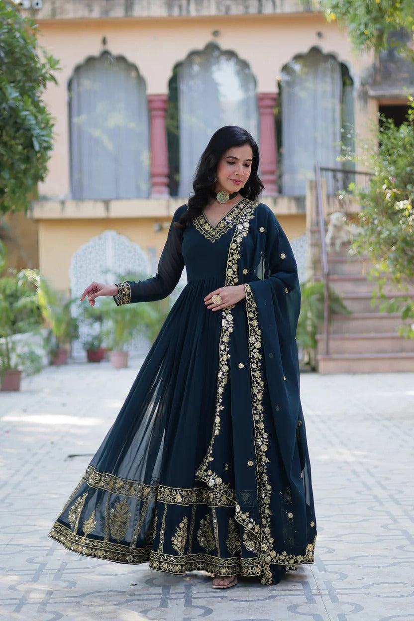 Dark teal blue green georgette Anarkali suit set featuring gold embroidered V-neck, floral hemline border, and matching organza dupatta